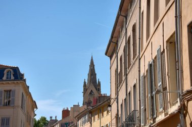 Gotik bir kilise kulesi, Aix-en-Provence 'ın merkezindeki geleneksel binaların çatıları ve cepheleri arasında yükseliyor..