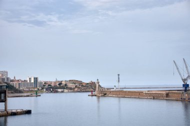 Marsilya Limanı 'nda, bu Akdeniz enklavının lojistik ve endüstriyel önemini yansıtan mavi gökyüzü altında birkaç vinç yükseliyor. Kompozisyon, net mimari çizgilerle düzen ve sağlamlığı iletir. 