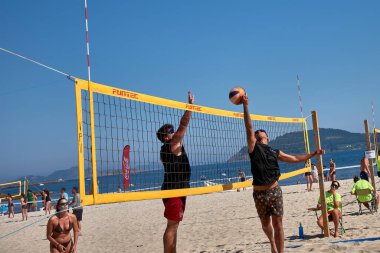 Sabaris, Bayonne, İspanya; 27 Temmuz 2025: Bir plaj voleybol maçında iki oyuncu yoğun bir şekilde karşı karşıya, biri blok yapmaya çalışıyor, diğeri de kollarını kaldırıyor.. 