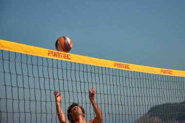 Sabaris, Bayonne, İspanya; 27 Temmuz 2025: Bir plaj voleybol maçında iki oyuncu yoğun bir şekilde karşı karşıya, biri blok yapmaya çalışıyor, diğeri de kollarını kaldırıyor.. 