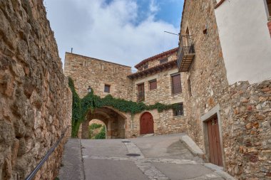 Görkemli Puertomingalvo kalesi, kendine özgü taş mimarisi ve yoğun yeşil sarmaşık tabakasının altında zarif bir şekilde kıvrılan büyük bir giriş kemeriyle küçük bir ortaçağ köyüne harmanlanır.. 