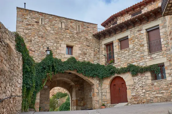 Görkemli Puertomingalvo kalesi, kendine özgü taş mimarisi ve yoğun yeşil sarmaşık tabakasının altında zarif bir şekilde kıvrılan büyük bir giriş kemeriyle küçük bir ortaçağ köyüne harmanlanır.. 