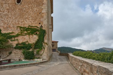 Puertomingalvo 'nun sevimli küçük köyünün sağlam taş duvarı görkemli bir şekilde, kısmen yeşil sarmaşıklarla kaplı, ona romantik ve eski bir his veriyor, sol üst köşesinde oyulmuş küçük bir Rosette. 