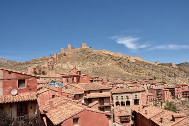 Ortaçağ Albarakin duvarı, sağlam gri taştan inşa edilmiş, tepenin sarp arazisinde yükseliyor ve rüzgarlar esiyor, sık köy evlerini kucaklıyor ve koruyor.. 