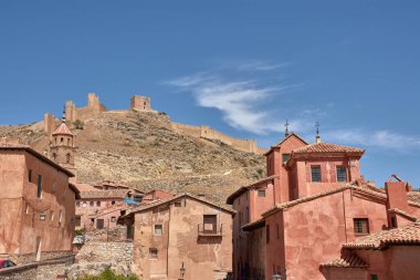 Ortaçağ Albarakin duvarı, sağlam gri taştan inşa edilmiş, tepenin sarp arazisinde yükseliyor ve rüzgarlar esiyor, sık köy evlerini kucaklıyor ve koruyor.. 