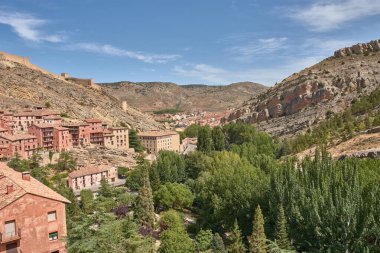 Ortaçağ Albarakin duvarı, sağlam gri taştan inşa edilmiş, tepenin sarp arazisinde yükseliyor ve rüzgarlar esiyor, sık köy evlerini kucaklıyor ve koruyor.. 