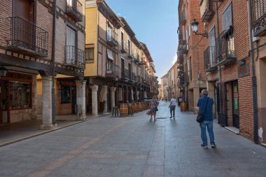 Burgo de Osma, Spain - September 9, 2025,A narrow alley with arcades in El Burgo de Osma, province of Soria, Castilla y Leon, Spain, characterized by its brick and stone facades, wrought iron balconies, and columns supporting the wooden roofs. 
