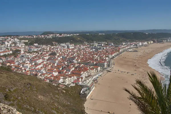 From a high vantage point, O Sitio, you can see Nazare beach stretching out along the ocean, with red roofs contrasting with the golden sand and blue sea. 