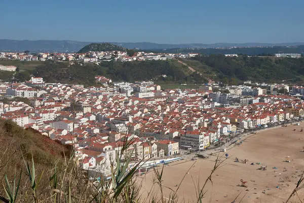 From a high vantage point, O Sitio, you can see Nazare beach stretching out along the ocean, with red roofs contrasting with the golden sand and blue sea. 