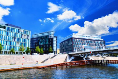 31.07.2024.Berlin. Almanya. Federal Basın Konferansı ve ofis binaları. Sağda Alman Federal Basın Konferansı binası var. Binaların karşısında nehrin üzerinde bir köprü var. Zevk teknesinden görüntü.