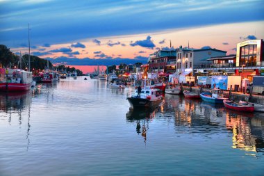 Warnemnde, Almanya -8 Ağustos 2024 - Fotoğraf, Rostock kentinin sahil beldesi ve bir ilçesini gösteriyor. Akşamları Warnemuende 'de tekneli kanal.