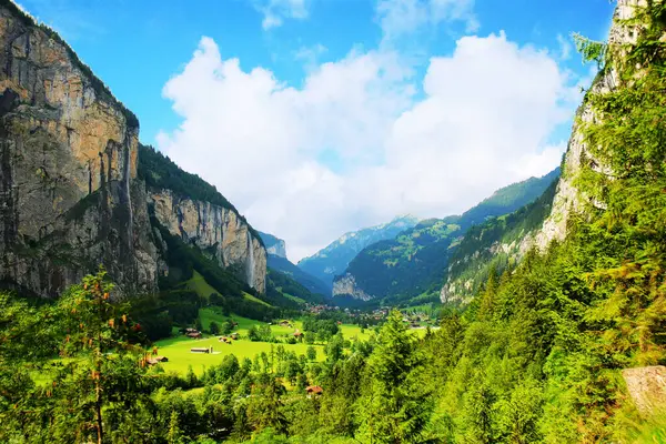 İsviçre. Interlaken 'in şehir manzarası. Yazın gün doğumunda berrak mavi gökyüzünün altında şelalesi olan güzel bir panorama..