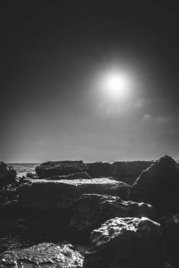 Güneş batarken sahilin siyah beyaz görüntüsü