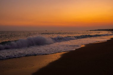 Türkiye sahilinde portakal rengi günbatımında bir dalganın fotoğrafı