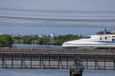 Japon Nozomi Shinkansen Mermi Treni 'nin önde gelen vagonu Nagoya şehrine girerken Shonai Nehri' ni geçen bir köprüde ele geçirildi. Yoro dağlarının yakın plan özellikleri.