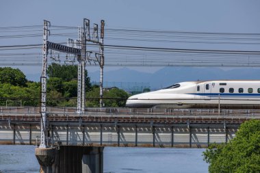  Japonya 'nın Nozomi Mermi Treni' nin öncü vagonu Nagoya 'ya girerken Shonai Nehri üzerindeki köprüde ele geçirildi. Yoro dağlarının yakın plan özellikleri.