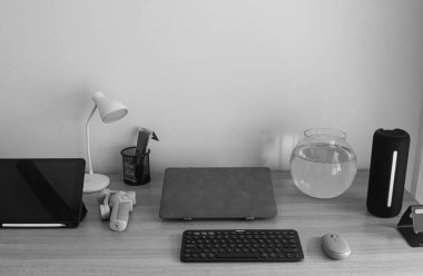 Mühendislik öğrencileri için çağdaş bir çalışma alanı, bir dizüstü bilgisayar, tablet, klavye, fare ve bir akvaryum ile düzenli bir masayı sergilemek, üretken bir öğrenme ortamını teşvik etmek..