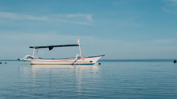 Mavi Gök 'ün altında sakin bir denizin ortasında boşta duran bir balıkçı kanosu..