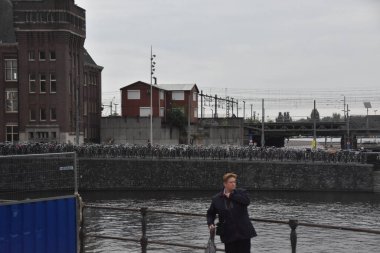 Amsterdam, Hollanda - 16 Nisan, 2016: insanlar ve onların kanalda yürüyüşleri