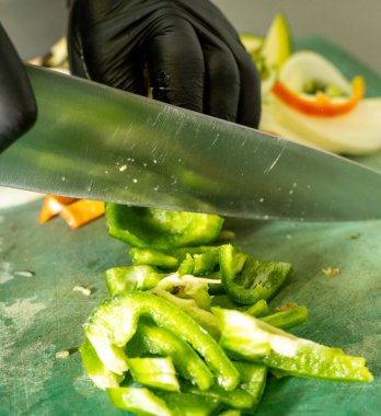 Mutfakta bıçakla yeşil biber doğramak.