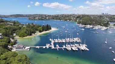 Mosman, Sydney, NSW, Avustralya 'nın nefes kesici hava manzarası. Kıyı güzelliği ve marina hayatı çarpıcı 4K insansız hava aracı görüntülerinde yakalandı.. 