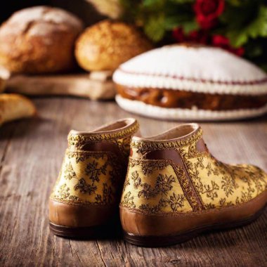 extreme macro traditional Bavarian shoes. The focus is on the intricate embroidery and rich textures of the clothing, set against a rustic wooden backdrop with Oktoberfest decorations. clipart