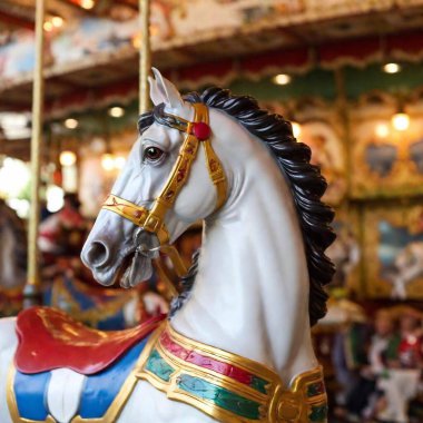 Oktoberfest 'te renkli bir atlıkarınca vuruşu. Eyer ve yelesinde karmaşık detaylar var. Askı odağı attan bulanık, dönen arka plana kayar, hepsi göz hizasında yakalanır..