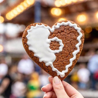 gingerbread heart shape with icing sugar on a wooden background. clipart