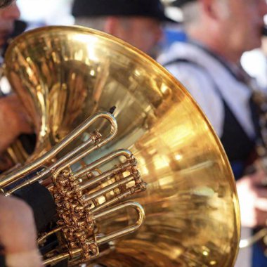 Extreme macro shot of a lively Oktoberfest beer tent, with a focus on the brass section of a Bavarian folk music band. The polished surface of a tuba catches the light as the rest of the scene softly fades into the background. clipart