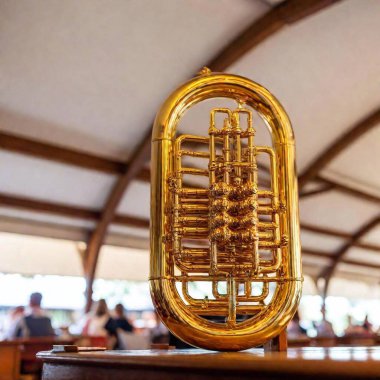 Extreme wide shot of a Bavarian beer tent interior, with a rack focus on an intricately carved wooden tuba stand holding a brass tuba. The detailed carvings are emphasized, as the surrounding tent decor softly blurs into the background clipart