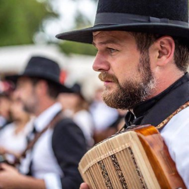 Extreme macro shot of a Caucasian male musician eye and the rim of his traditional Bavarian hat as he plays the accordion at Oktoberfest. The focus is on the textures of the eye and hat, with the accordion buttons softly blurred. clipart