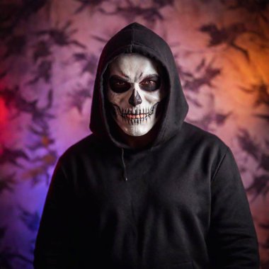 Caucasian male in a scary Halloween costume, captured in an extreme wide shot. skull make up on face, eerie costume, blur neon background clipart