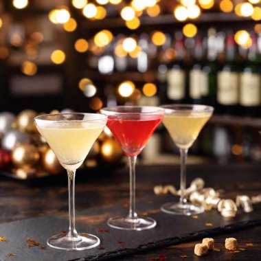 A close-up, ground-level photo of a New Year Eve cocktail setup, including a selection of chic drinks and gourmet snacks, with a split diopter effect to showcase the elegance of the presentation and the festive decor in the background clipart