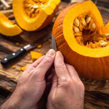 A macro photo of a caucasian male adult fingers smoothing the edges of a freshly carved section of a pumpkin, deep focus showing the detailed texture of the pumpkin and his hands, eye level shot emphasizing the craftsmanship clipart