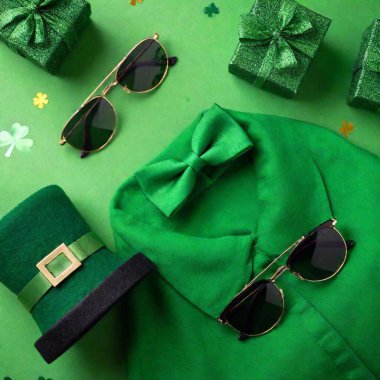 Saint Patrick Day accessories concept. macro Top view photo of green clothing shirt irish party glasses leprechaun cap suspenders bow-tie trefoils and confetti on green background clipart