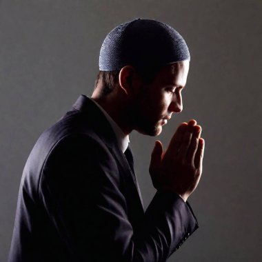 silhouette of male, with a kippah, shown in profile as he prays clipart