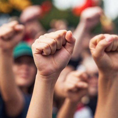 extreme close up image of women raising their fists in the air during a rally, with a focus on their strong, determined faces and the intensity of their collective voice demanding change. clipart