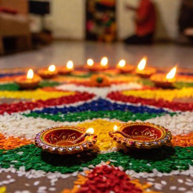 Ön planda Diwali Rangoli tasarımı üzerinde yoğunlaşmak için bölünmüş bir diyopter kullanarak orta boy fotoğraf çekilirken, aynı zamanda dekore edilmiş bir ev ya da festival pazarı gibi bir Diwali kutlamasının arka plan sahnesini de net bir şekilde muhafaza ediyor..