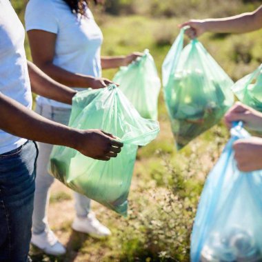 Close-up shot of a group of volunteers' hands holding trash bags filled with recyclables, with one bag in sharp focus and the others softly fading, highlighting teamwork in Earth Day efforts clipart