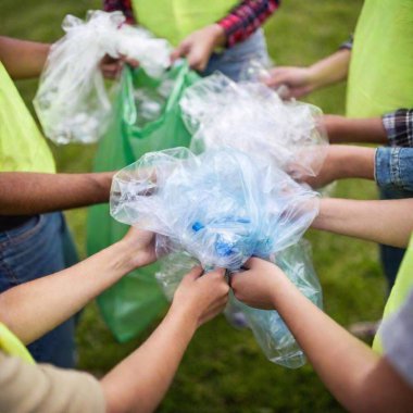 extreme macro shot of a group of volunteers' hands holding trash bags filled with recyclables, with one bag in sharp focus and the others softly fading, highlighting teamwork in Earth Day efforts clipart