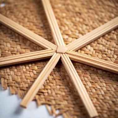 A macro flatlay of Christmas Eve preparations in a Polish home, with an extreme close-up of the fine details on a piece of traditional straw decoration, such as a star or angel, against a flat surface clipart