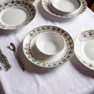 A flatlay close-up of Polish Christmas Eve tableware, featuring the fine details of traditional ceramic plates, ornate cutlery, and the texture of a white tablecloth adorned with Christmas motifs clipart