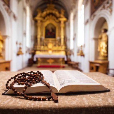 Close-up of rosary beads and open Bible, broader view of decorated church altar clipart