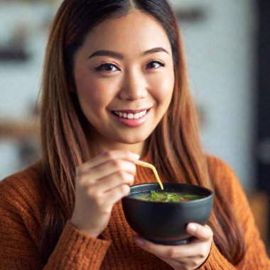 asian woman holding a bowl of noodles, chopsticks with chopsticks, close up, smiling clipart