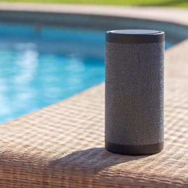 black speaker on the table near the pool in the garden. clipart