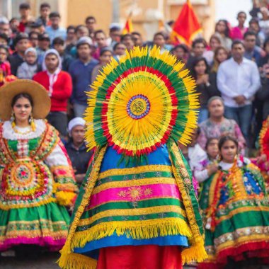 Illustrate an extreme wide shot of Virgin of Guadalupe Day festivities with deep focus and a from-above angle. Show both female and male participants across a large area, with vibrant decorations and festive elements filling the frame clipart