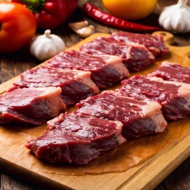 raw beef steaks on a wooden cutting board, top view. clipart