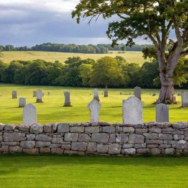 old stone cemetery with a large stones on the background of a beautiful sky clipart