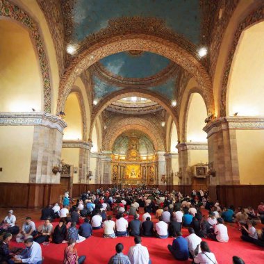 A sweeping wide-angle view of the Basilica of Our Lady of Guadalupe during a major religious ceremony, showing the grandeur of the church, the crowds of pilgrims, and the festive atmosphere clipart