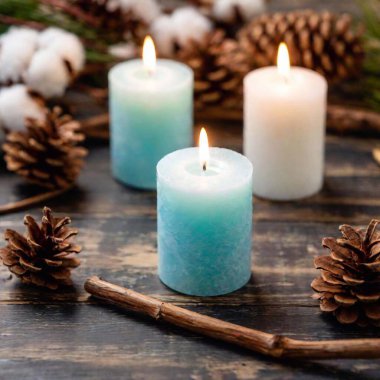 blue christmas candle and christmas tree branches on white wooden background clipart